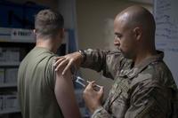 U.S. Air Force Medical Technician delivers a COVID-19 booster.