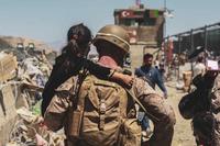 Marine carries a child during evacuation at Hamid Karzai International Airport.