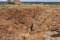 A U.S. Army soldier with Charlie Troop, 1st Squadron, 102nd Cavalry Regiment, New Jersey Army National Guard, stands in a crater created by a vehicle-borne improvised explosive device at Baledogle Military Airfield, Federal Republic of Somalia.