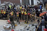 Security officials and rescue workers gather at the site of suicide bombing, in Peshawar, Pakistan