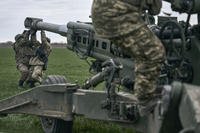 Ukrainian soldiers prepare a U.S.-supplied M777 howitzer to fire at Russian positions.