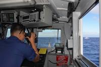 U.S. Coast Guard members patrol offshore.
