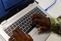 An airman types at a computer.