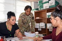 A human resources specialist confers with transition leads at Fort Bliss.