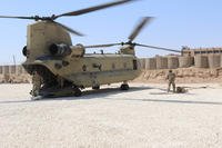 A Task Force Phoenix CH-47 Chinook helicopter from B Company, 1st Battalion, 171st Aviation Regiment (General Support Aviation Battalion), sits on the landing pad at a forward operating base in Syria. (