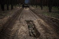 A Ukrainian serviceman lies in a trench during a military exercise in the Kharkiv region