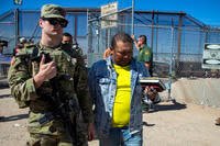 Migrants escorted by a U.S. Army soldier after entering into El Paso