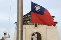 Two soldiers lower the national flag during the daily flag ceremony on Liberty Square of the Chiang Kai-shek Memorial Hall