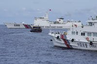 Philippine supply boat, center, maneuvers around Chinese coast guard ships as they try to block its way near Second Thomas Shoal