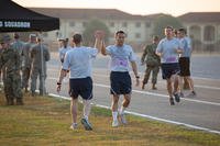 Officer Training School trainees high-five one another after completing their first official Air Force physical training (PT) test at Maxwell Air Force Base, Alabama.