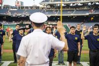 Vice Adm. Jon Hill gives the oath of enlistment at Nationals Park