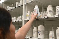 pharmacy technician pulls medication from storage
