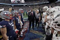 Defense Secretary Lloyd Austin flips the coin before the 2021 Army-Navy football game in East Rutherford, N.J. 