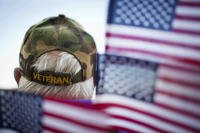 Frank Lindsey wears a veteran’s hat surrounded by flags as he attends a Veterans Day parade on Nov. 11, 2014, in Montgomery, Ala. 