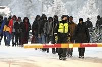 Finnish Border Guards escort migrants at the international border.