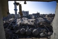 Palestinians look at the destruction after an Israeli strike