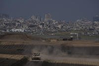 Israeli soldiers move on the top of a tank near the Israeli-Gaza border