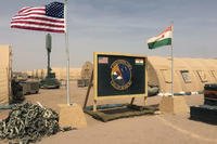 A U.S. and Niger flag are raised side by side at the base camp
