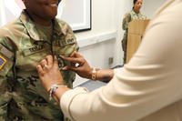 Porchea Taylor pins sergeant 1st class rockers on her wife, U.S. Army Reserve Sgt. 1st Class Lavasia Taylor, the training noncommissioned officer for Headquarters and Headquarters Company, 7th Mission Support Command, during her promotion ceremony at Kleber Kaserne, Kaiserslautern, Germany.