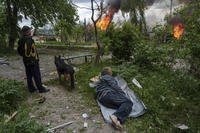 A man watches his burning house destroyed by a Russian airstrike.