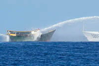 Philippine resupply vessel Unaizah May 4, left, is hit by two Chinese coast guard water canons