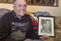 World War II veteran Andy Negra sits in his home