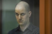 Wall Street Journal reporter Evan Gershkovich stands in a glass cage in a courtroom in Yekaterinburg