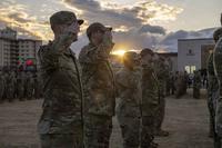 Military members salute during a retreat ceremony at Yokota Air Base, Japan
