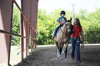 An Exceptional Family Member Program athlete, participates in an exercise using listening skills and balance during a Special Olympics equestrian camp at the Joint Base San Antonio-Fort Sam Houston Equestrian Center.