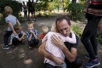 A father hugs his daughter as they wait for evacuation in Ukraine.