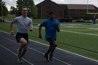 U.S. Air Force Airman 1st Class Timothy Joiner and Airman 1st Class Oliver Guzman-Cespedes, both 509th Civil Engineer Squadron electrical power production technicians, race to finish the final lap of the Murph workout at Whiteman Air Force Base, Missouri.