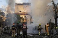 Israeli security and rescue forces work at the site hit by a rocket fired from Lebanon.