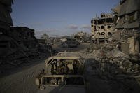 Israeli soldiers move next to destroyed buildings following Israeli strikes.