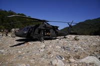 Army National Guard members stand outside of a Black Hawk helicopter