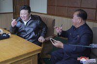 Kim Jong Un, left, inspects tests of drones designed to crash into targets