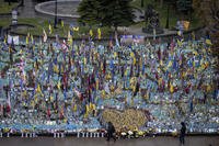 People walk past the memorial to fallen soldiers in Independence Square in Kyiv, Ukraine
