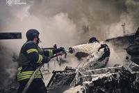 rescue workers extinguish a fire of a building destroyed by a Russian strike in Brovary