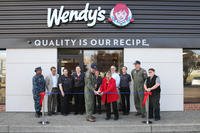 Capt. Geoff Moore, commanding officer, Naval Air Station Whidbey Island, and Donna Smith, district manager, Wendy's, cut the ribbon marking the grand opening of the new Wendy's restaurant on base on July 19, 2016.