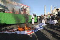 Yemen's Houthi supporters burn Israeli and U.S. flags during a demonstration against the United States and Israel following Israeli airstrikes on significant facilities in the Yemeni cities of Sana'a and Hodeidah.