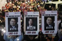 Protesters with images of South Korean President Yoon Suk Yeol and former South Korea Defense Minister Kim Yong Hyun, center, march to the presidential office after a candlelight vigil against President Yoon in Seoul, South Korea, on Dec. 5, 2024. The signs read 'Arrest the rebellion criminals.'