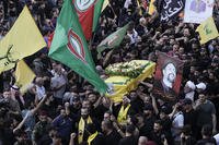 Hezbollah fighters carry one of the coffins of four fallen comrades