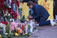A University of New Orleans student lights a candle at memorial on Bourbon Street.