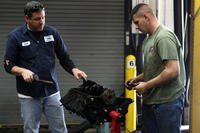 An employee of the Auto Hobby Shop aboard Marine Corps Base Camp Lejeune, N.C., assists a patron.