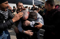 Palestinian prisoners are greeted as they exit a Red Cross bus.