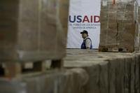 A man walks past boxes of USAID humanitarian aid at a warehouse at the Tienditas International Bridge