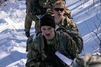 Army ROTC cadets from Norwich University in Vermont complete the final steps of the SKEDCO drag carry during the Northern Warfare Challenge on Feb. 25 at Grandad Bluff in La Crosse, Wis.