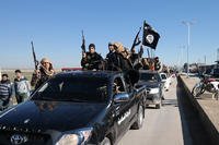 Islamic State militants drive in a convoy through Tel Abyad, northeast Syria