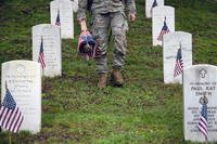 A service member places U.S. flags at Arlington National Cemetery during the annual flags-in ceremony in Arlington, Virginia, on May 22, 2025, as part of the Memorial Day holiday.