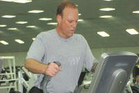 Chief Warrant Officer Greg Gransback uses an elliptical trainer at the gym on Camp Victory, Iraq.