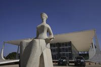 Lady Justice statue, depicting a seated, blindfolded woman holding a sword, stands outside the Supreme Court in Brasilia, Brazil